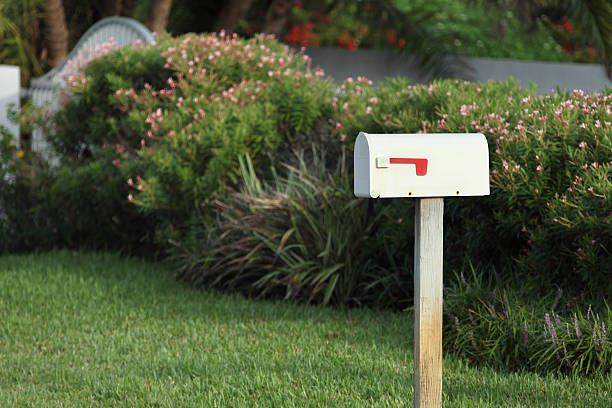 white metal mail box in front of a house.